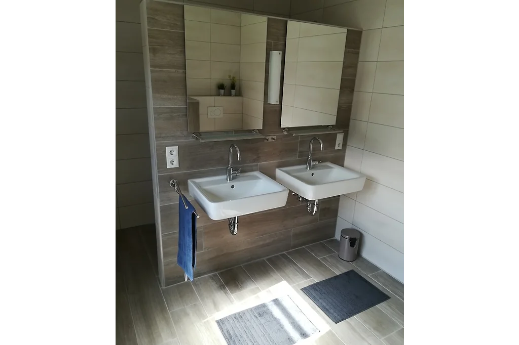 Badezimmer mit zwei Waschbecken nebeneinander und zwei Spiegelschränken