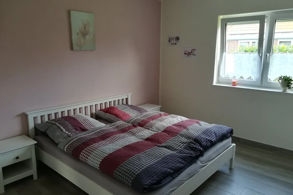 Schlafzimmer mit weißem Doppelbett, zwei Nachttischen und Fenster